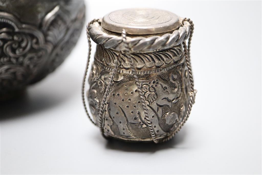 An Indonesian? embossed and engraved white metal squat vase, height 12.2cm and two similar lidded pots,